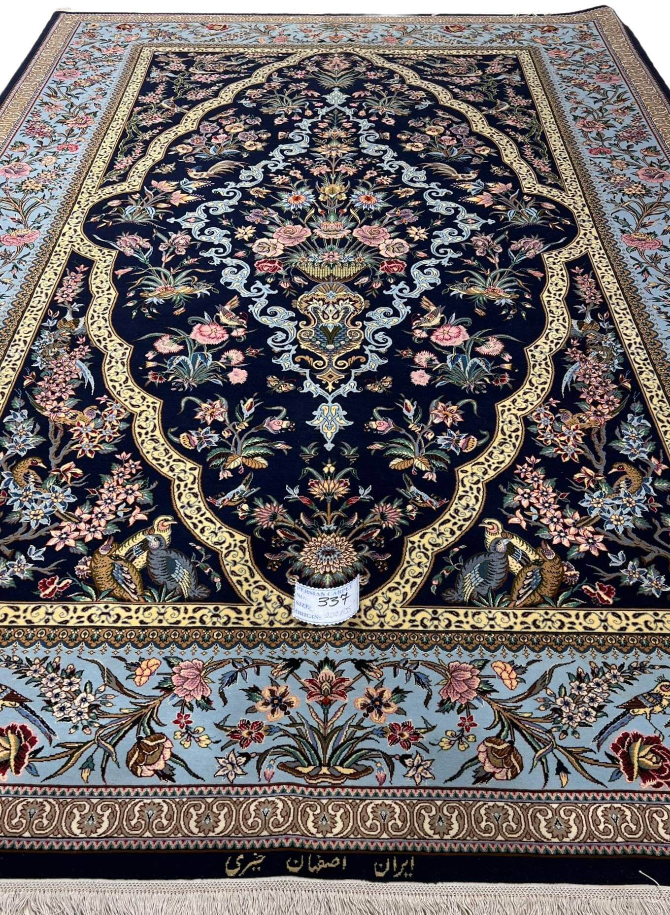 "Luxury hand-knotted Isfahan Persian rug featuring intricate floral and peacock motifs on a navy background."
